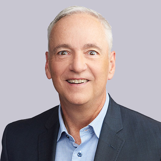 A headshot of Dr. Gary Call, M.D., Senior Vice President and Chief Medical Officer at Gainwell Technologies, smiling in a blue suit with no tie.