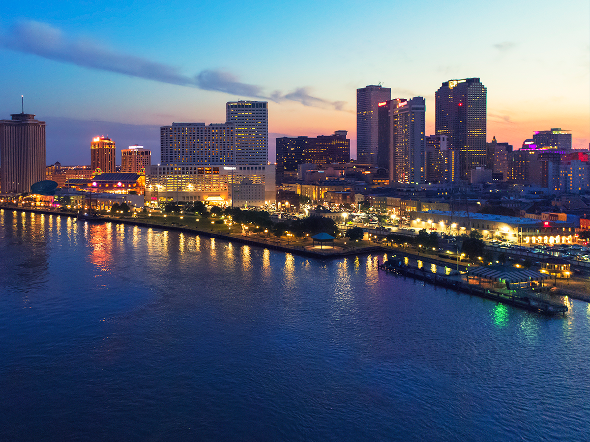 A dusk shot of the New Orleans skyline, with the water in the foreground