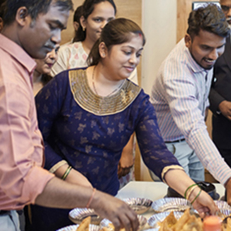 Professionals celebrating birthday at creative workplace. Colleagues are standing in board room. They are at office.